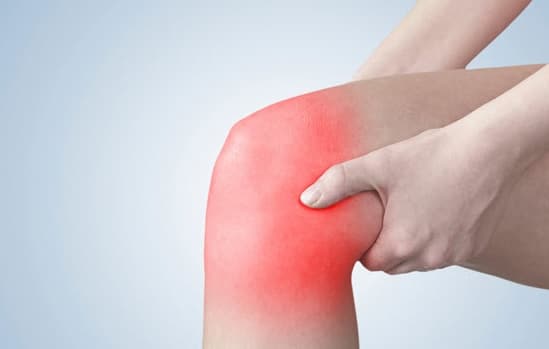 Picture of a leg highlighted in red around the knee while patient holds it. 