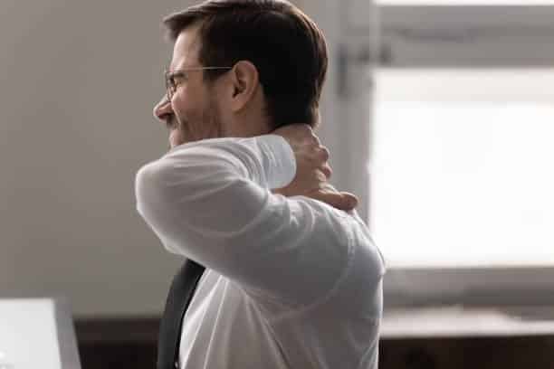 man massaging his neck causing pain because of Chronic fatigue syndrome
