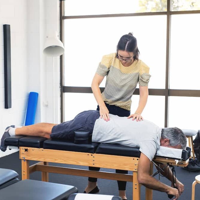 chiropractor doing some spine adjustment to the patient.