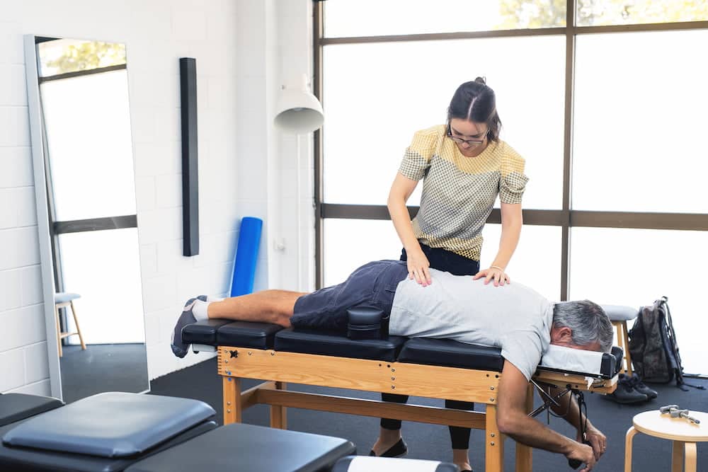 chiropractor doing some spine adjustment to the patient.