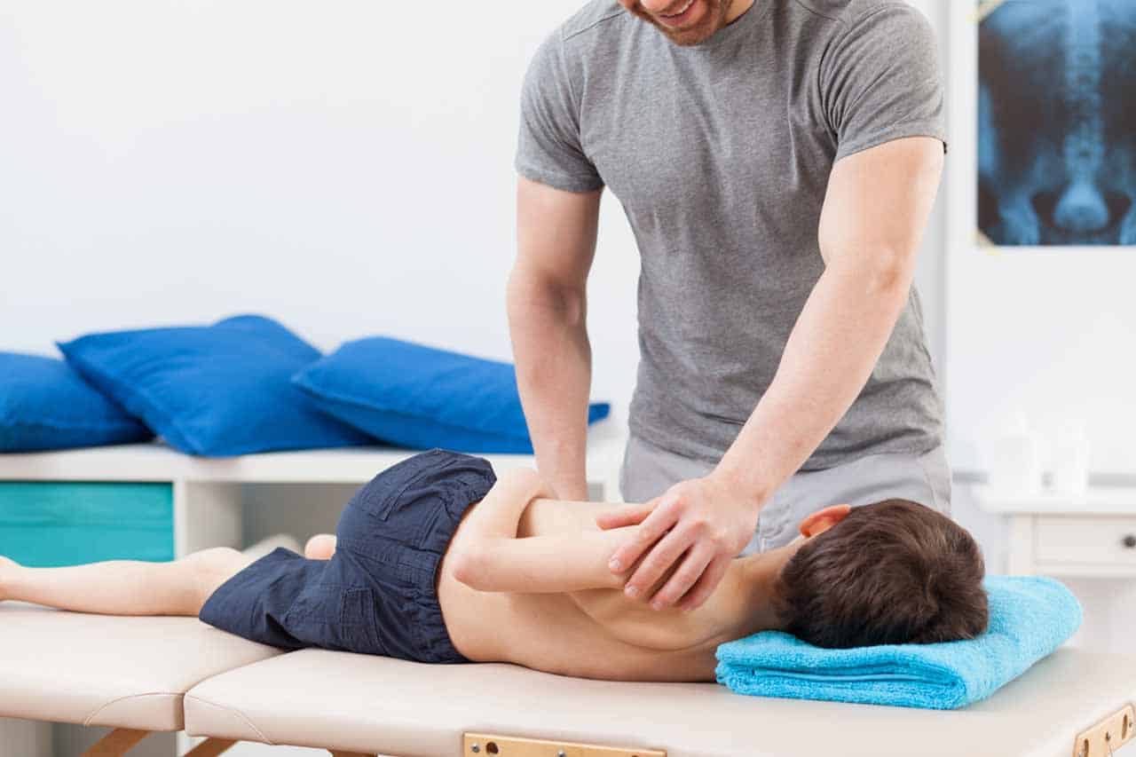 Boy lying on treatment table, pediatric care.