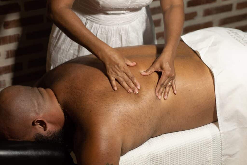 Massage therapist applying pressure to a patient’s back to relieve muscle tension.